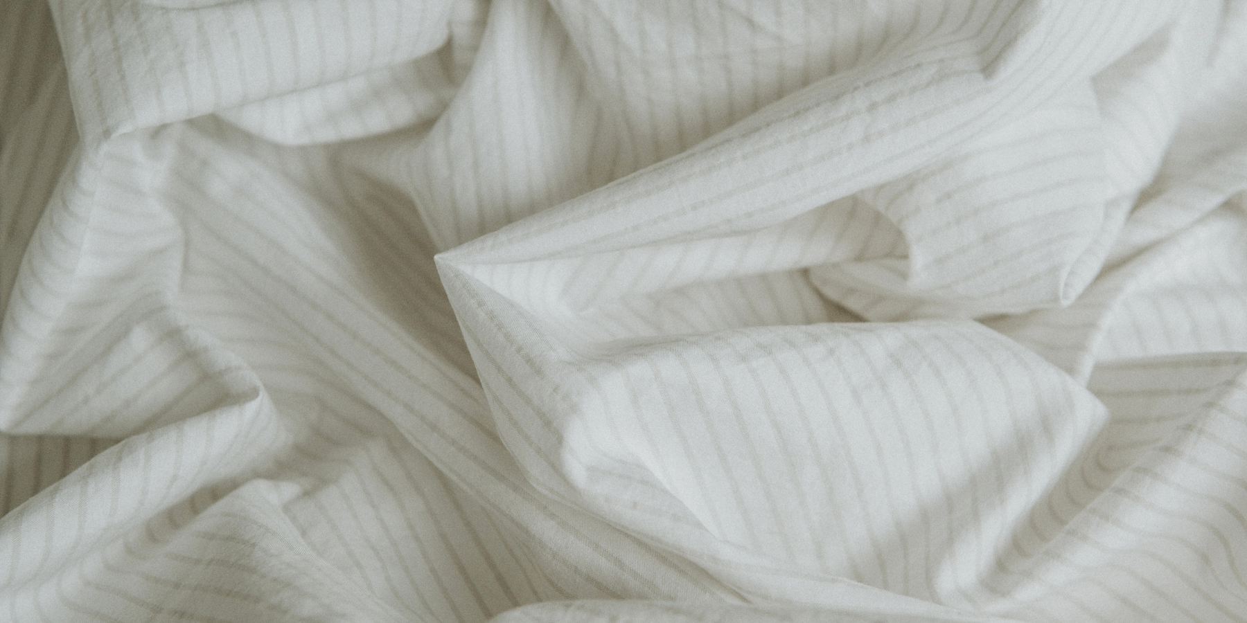 Close up of Tuck's crisp, pinstriped cooling bedsheet.