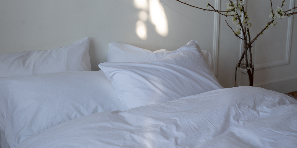 Cozy, crisp white bed setting with duvet and pillows.