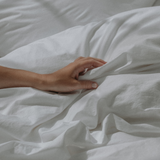 Crumpled bedsheets and hand touching them - Percale cotton sheets 